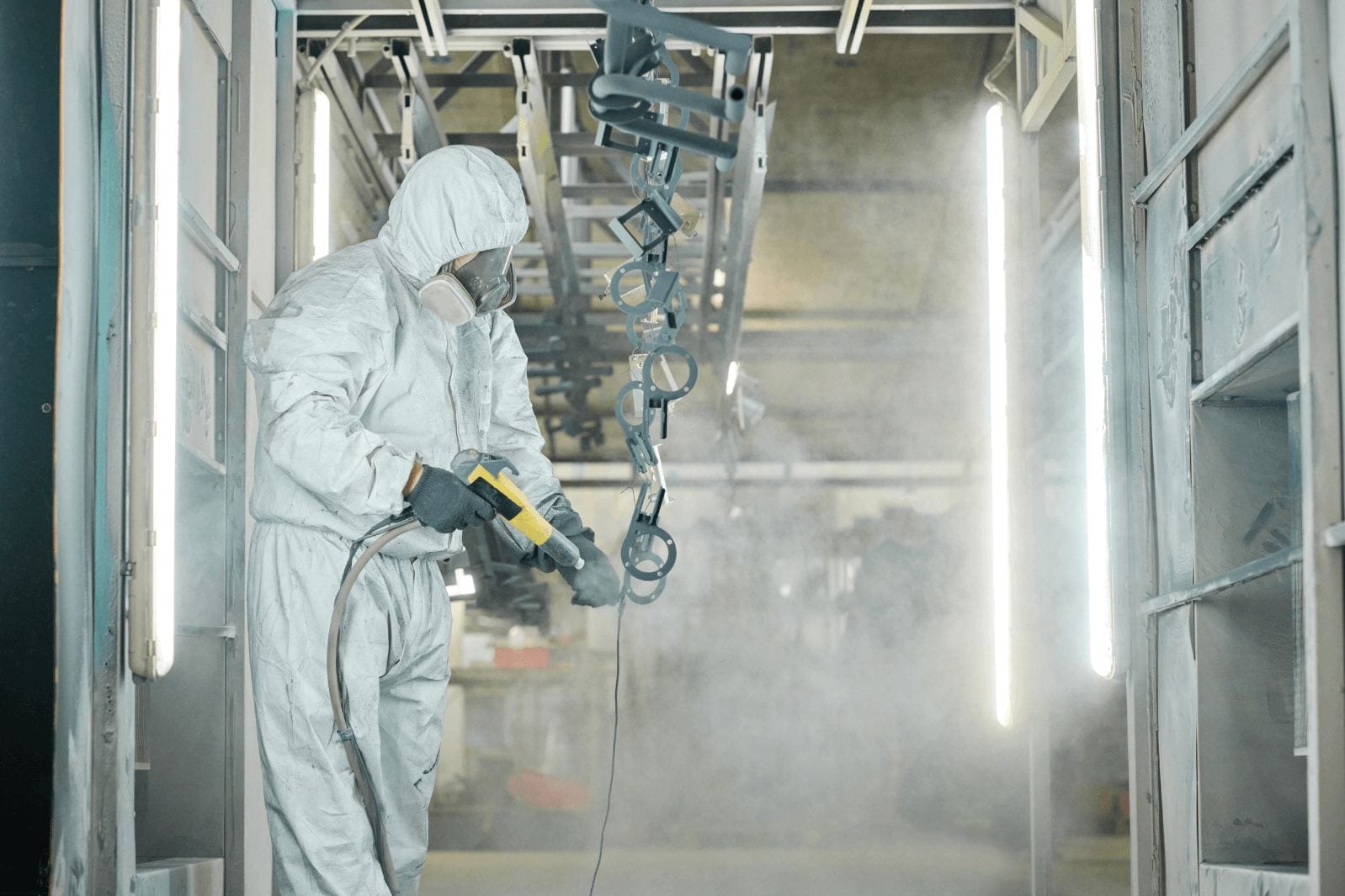 coating spray nozzles attached to machinery over conveyor